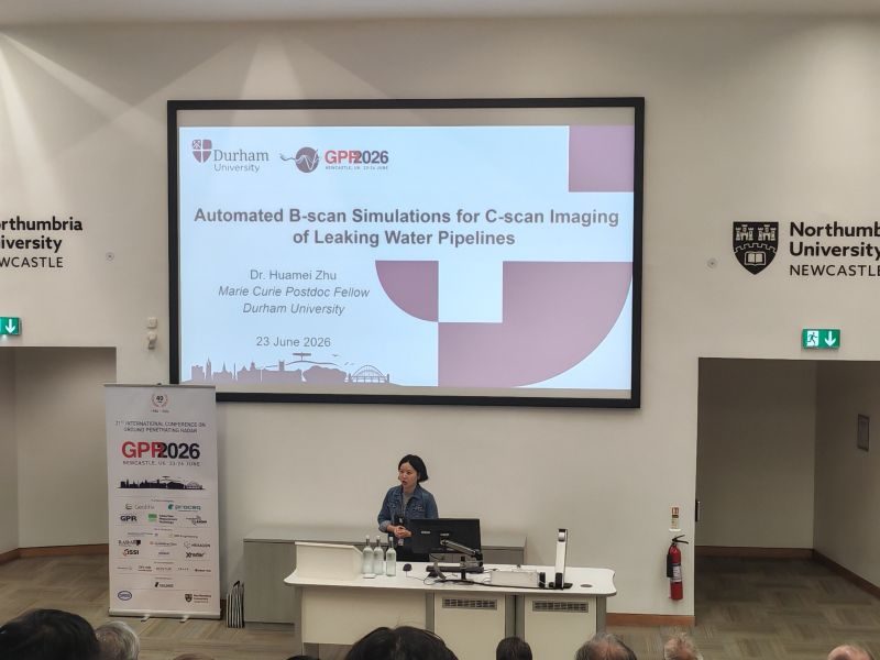 Huamei Zhu giving a talk at GPR 2026 in Newcastle, with the title slide on screen.